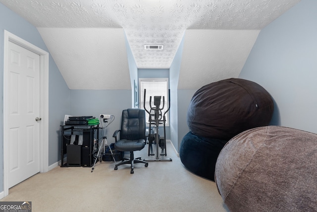 office with carpet, visible vents, vaulted ceiling, and a textured ceiling