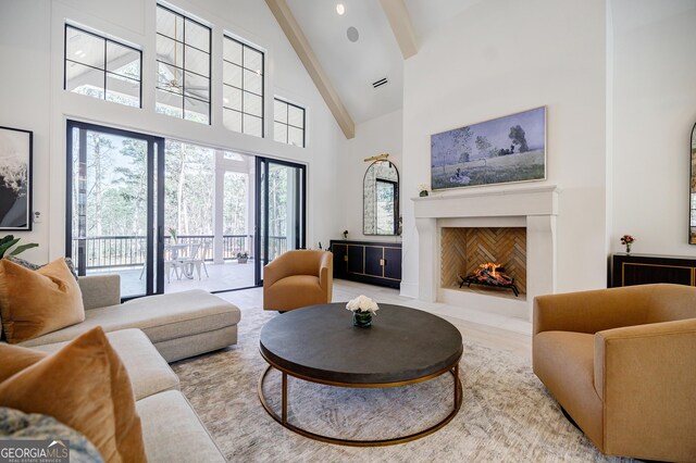 living room with beamed ceiling, visible vents, high vaulted ceiling, and a fireplace with flush hearth