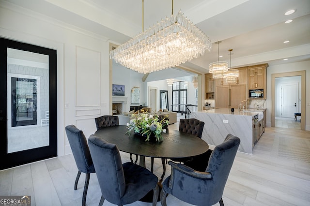 dining room featuring a chandelier, recessed lighting, light wood-style flooring, and a fireplace