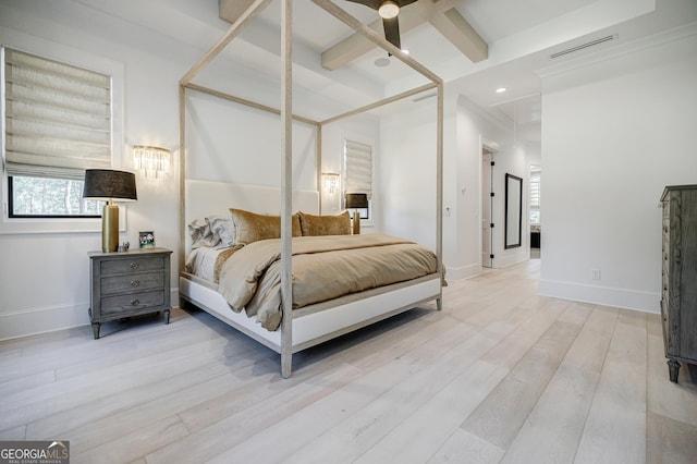 bedroom featuring visible vents, baseboards, beamed ceiling, and wood finished floors