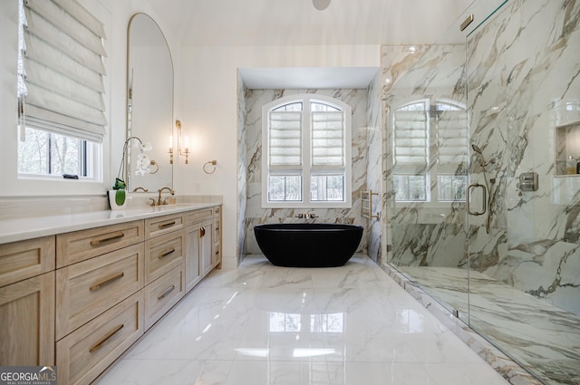 full bathroom with a freestanding tub, a marble finish shower, marble finish floor, and vanity