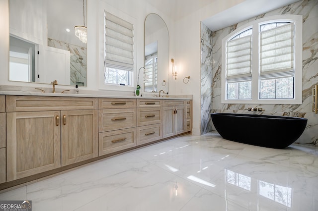 bathroom featuring a healthy amount of sunlight, marble finish floor, and a sink