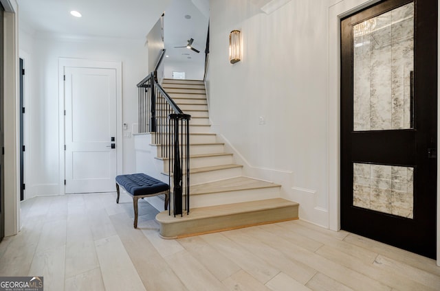 foyer entrance with recessed lighting, stairs, and light wood-style floors