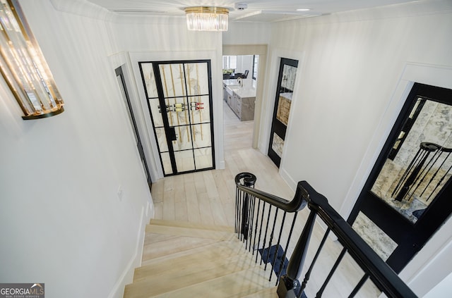 staircase featuring an inviting chandelier and wood finished floors