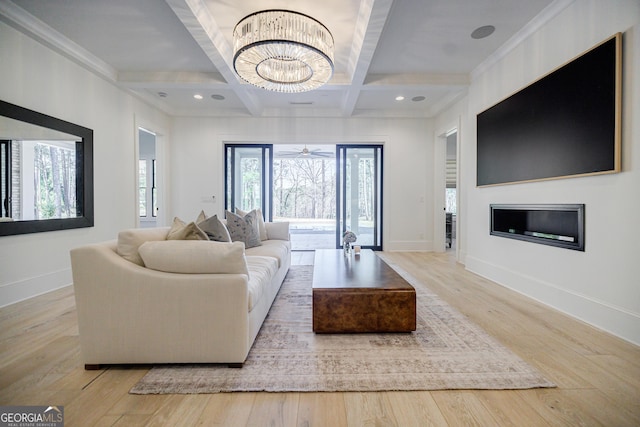 living room featuring beamed ceiling, a notable chandelier, coffered ceiling, wood finished floors, and baseboards