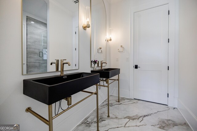 full bath featuring a shower stall, baseboards, marble finish floor, and a sink