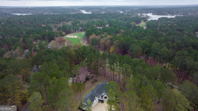 birds eye view of property featuring a water view and a wooded view