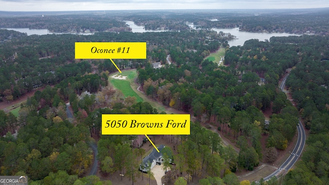 birds eye view of property with a forest view and a water view