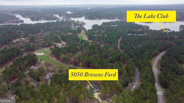 birds eye view of property with a view of trees and a water view