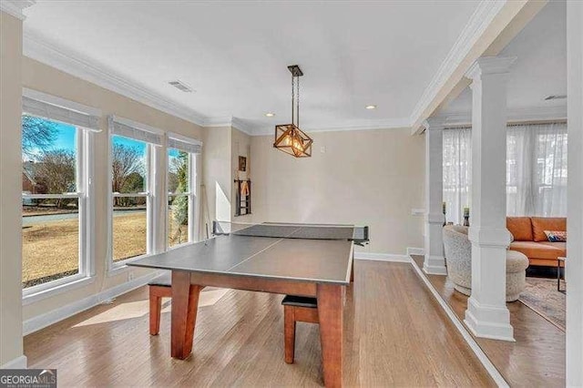 recreation room with ornamental molding, visible vents, decorative columns, and wood finished floors