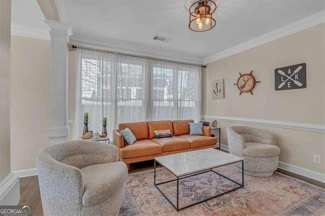 living room with visible vents, crown molding, ornate columns, and wood finished floors