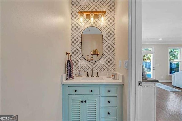 bathroom featuring baseboards, vanity, and crown molding