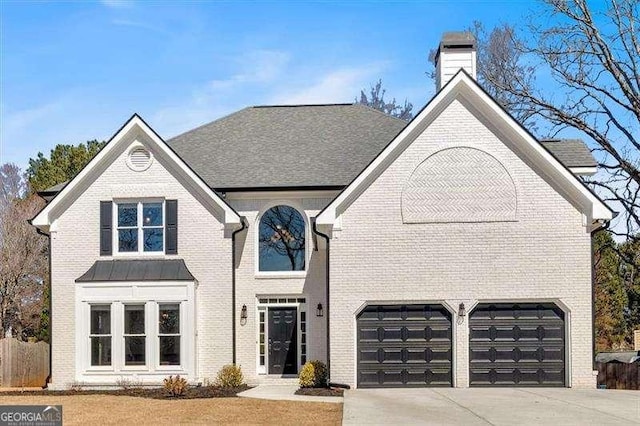 view of front of property featuring an attached garage, a chimney, concrete driveway, and brick siding