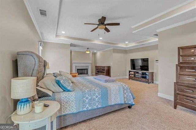 bedroom featuring a tray ceiling, carpet, visible vents, and crown molding