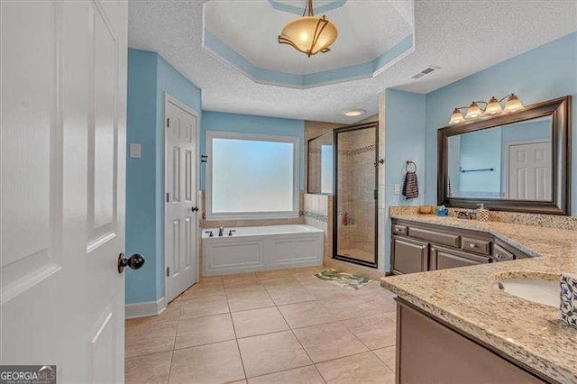 full bath with a textured ceiling, tile patterned flooring, a garden tub, vanity, and a shower stall