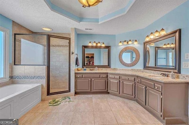 full bath with double vanity, a stall shower, tile patterned flooring, a textured ceiling, and a bath