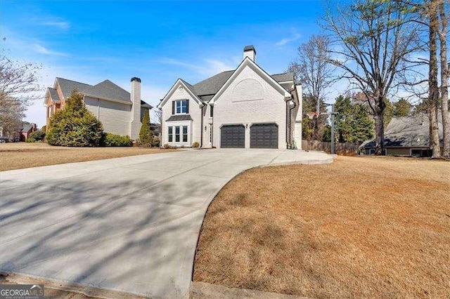 view of front of house featuring a garage, driveway, and a front lawn