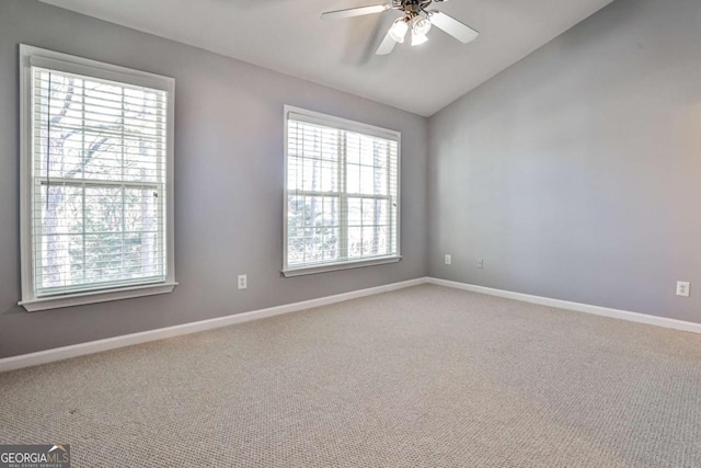 carpeted spare room with lofted ceiling, ceiling fan, and baseboards