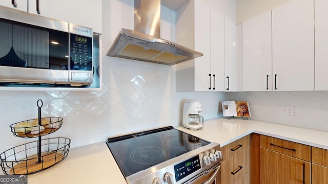 112 Rogers St Unit 409, Atlanta, GA 30317 - kitchen with white cabinetry, light countertops, wall chimney range hood, appliances with stainless steel finishes, and decorative backsplash