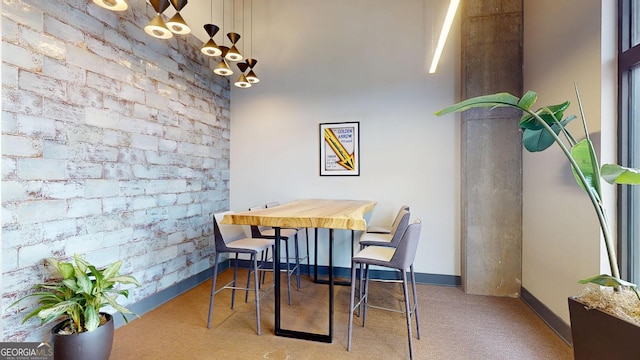 112 Rogers St Unit 409, Atlanta, GA 30317 - carpeted dining space with brick wall and baseboards
