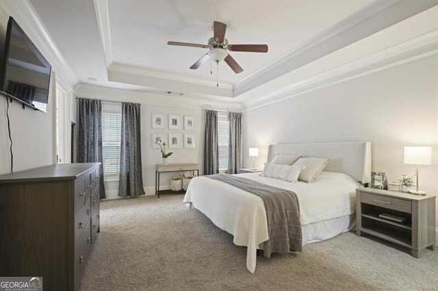 bedroom featuring crown molding, a raised ceiling, a ceiling fan, and light colored carpet