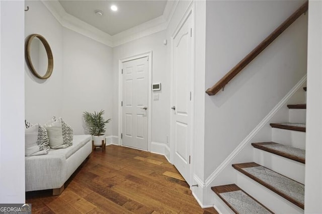 foyer featuring recessed lighting, wood finished floors, baseboards, stairs, and crown molding