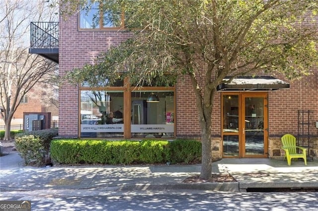 entrance to property featuring brick siding and a balcony