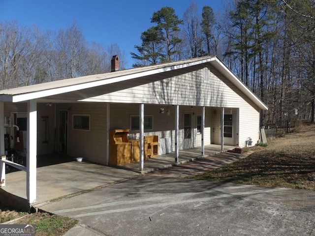 view of front of home with an attached carport and a chimney