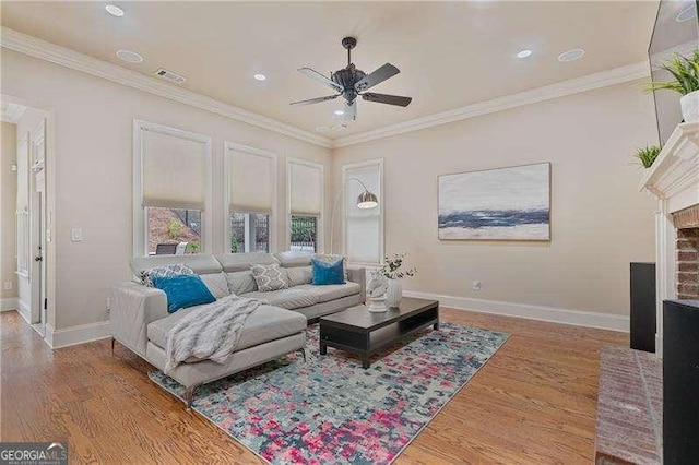 living room with wood finished floors, visible vents, and crown molding