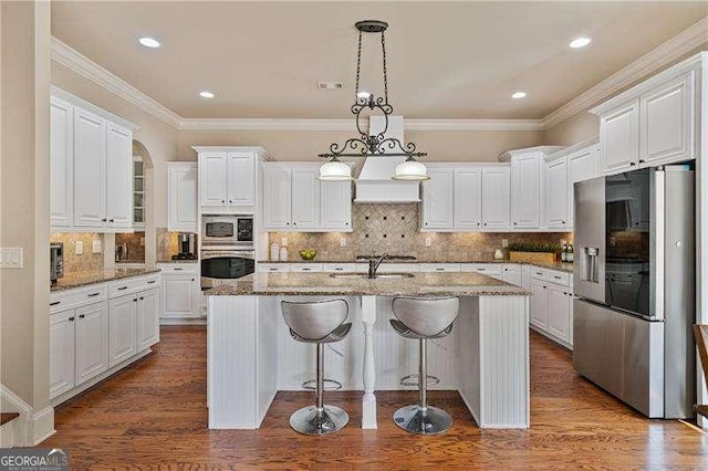 kitchen with dark wood-style floors, stainless steel appliances, ornamental molding, and white cabinets