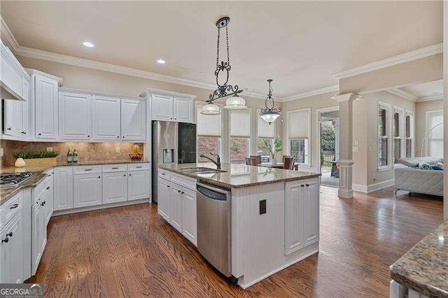 kitchen with appliances with stainless steel finishes, dark wood-type flooring, a sink, and ornate columns