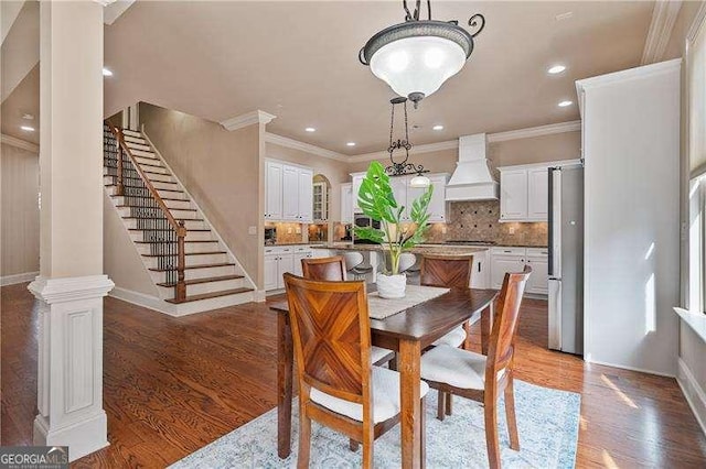 dining space with ornamental molding, stairway, wood finished floors, and recessed lighting