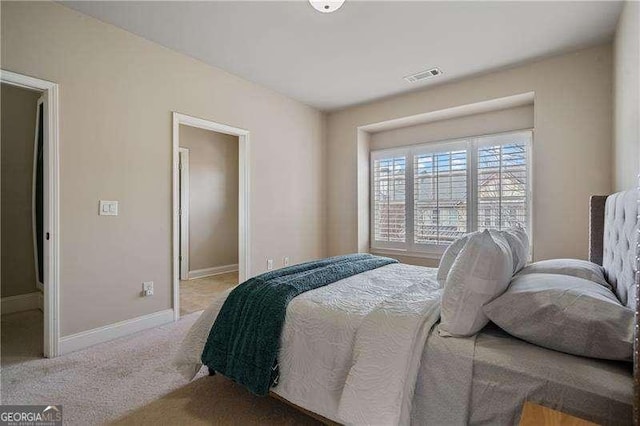 bedroom with carpet floors, visible vents, and baseboards