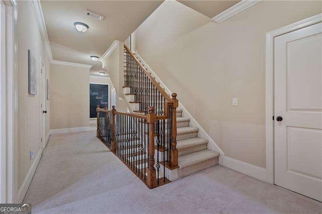 stairway featuring baseboards, visible vents, ornamental molding, and carpet flooring