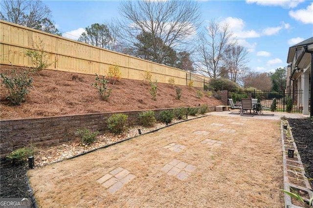 view of yard featuring a patio area, a fenced backyard, and outdoor dining space