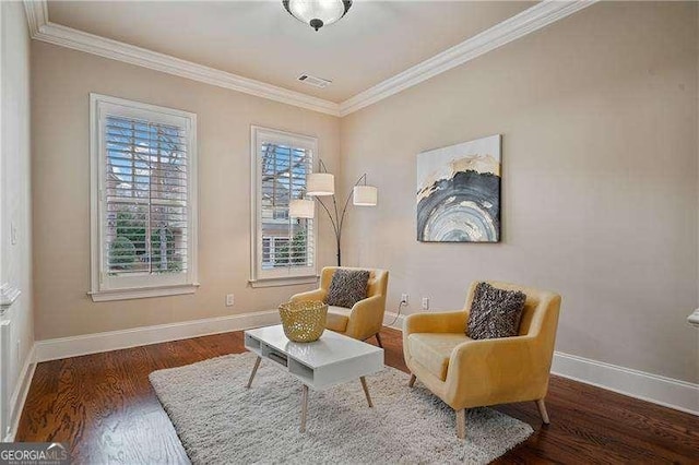 sitting room featuring baseboards, wood finished floors, visible vents, and crown molding