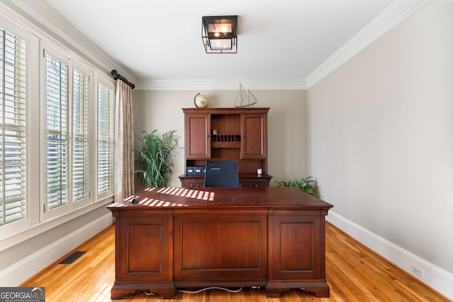 office with light wood finished floors, visible vents, crown molding, and baseboards