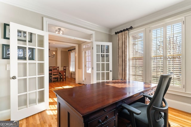 office featuring crown molding, a healthy amount of sunlight, and light wood-style floors