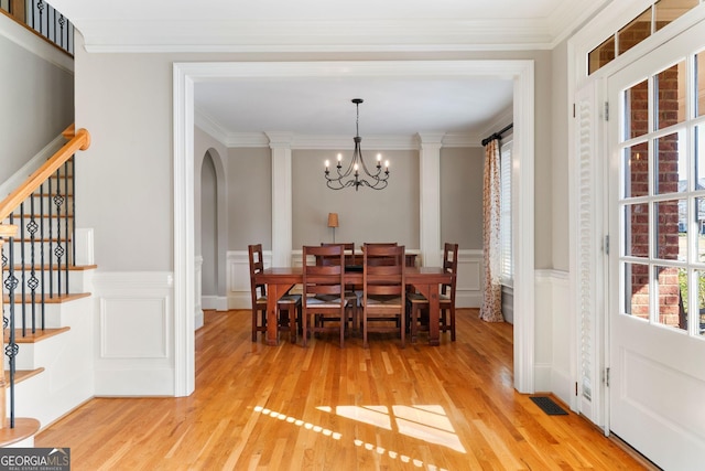 dining space featuring stairway, a notable chandelier, light wood-style floors, and visible vents