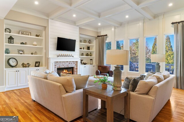 living area with beam ceiling, light wood-style flooring, and coffered ceiling