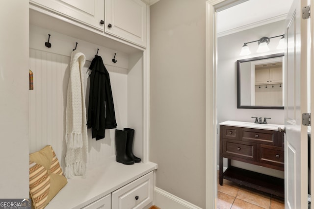 mudroom featuring baseboards, light tile patterned flooring, and ornamental molding