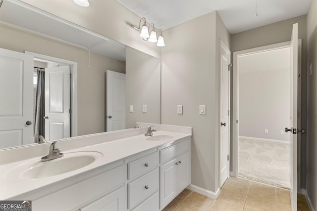 full bathroom featuring tile patterned flooring, double vanity, baseboards, and a sink