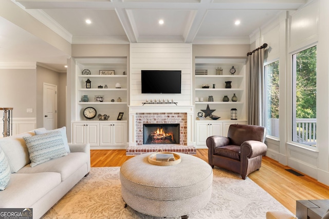 living room featuring built in shelves, light wood-type flooring, and coffered ceiling