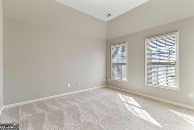 unfurnished room featuring visible vents, light carpet, and baseboards