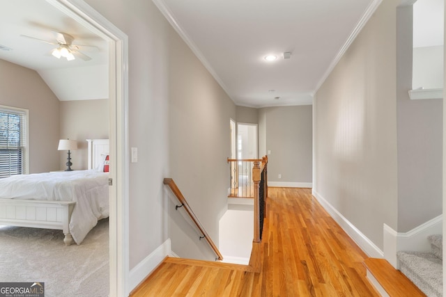 hall with an upstairs landing, visible vents, crown molding, and baseboards