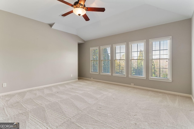 spare room with lofted ceiling, light colored carpet, baseboards, and ceiling fan