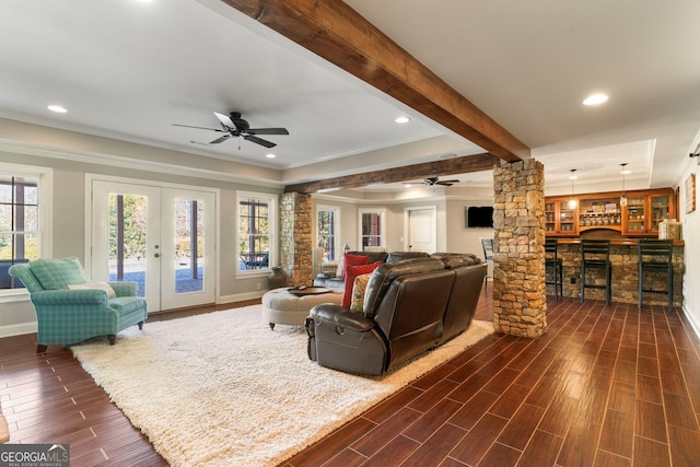 living room featuring wood tiled floor, decorative columns, ceiling fan, french doors, and beamed ceiling