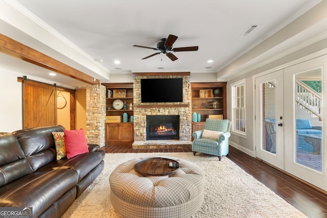 living room featuring visible vents, dark wood-type flooring, a barn door, ornamental molding, and french doors