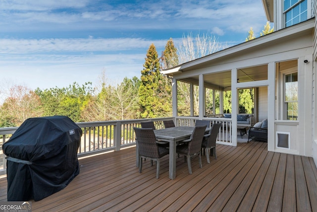 wooden terrace featuring outdoor dining space and grilling area