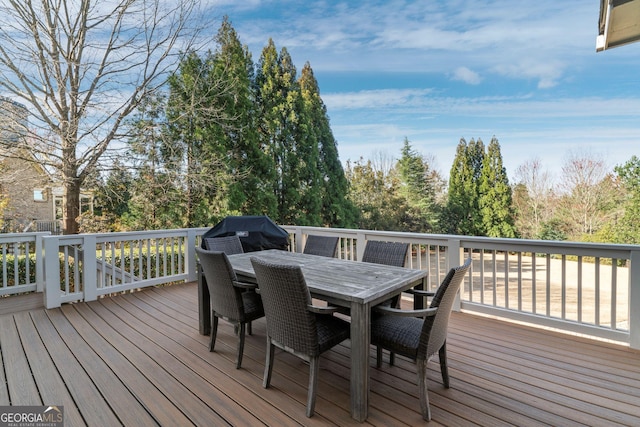 deck featuring outdoor dining space and grilling area